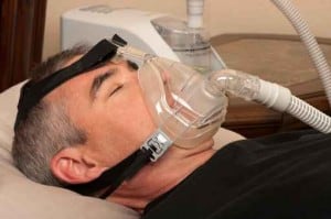 Man with sleep apnea using CPAP machine