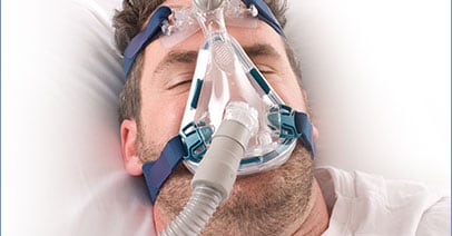 a man sleeping wearing a CPAP machine