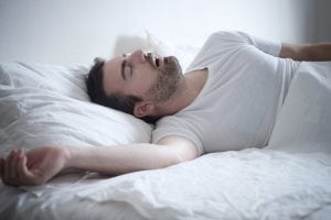 man snoring in bed