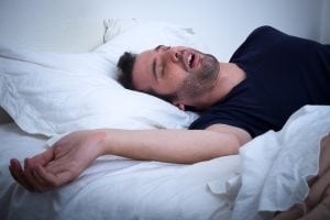 man snoring in bed