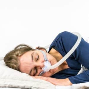 Woman using Oral Appliance Machine to help breathing during sleep