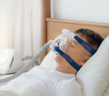 man wearing cpap mask sleeping smoothly on his back pillow high without snoring