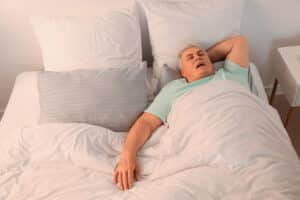 Older man sleeping and snoring due to sleep apnea